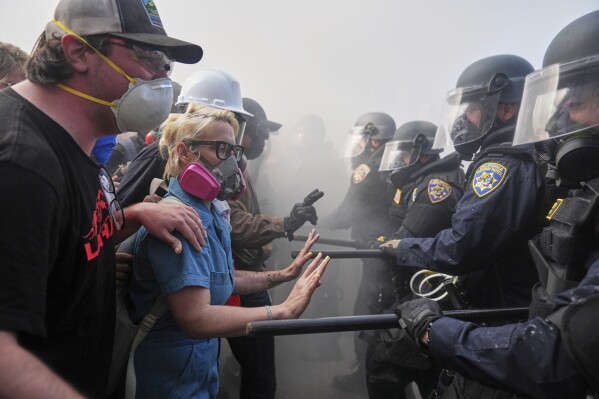 Manifestantes enfrentan a la policía en la autopista 101 Freeway cerca del Centro de Detención Metropolitano en el centro de Los Ángeles, domingo 8 de junio de 2025, tras una protesta contra redadas de inmigración. (AP Foto/Jae C. Hong)