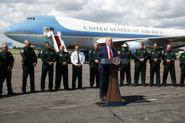 With Air Force One in the background, President Donald Trump speaks during a campaign event with Florida Sheriffs in Tampa, Fla., Friday, July 31, 2020. (AP Photo/Patrick Semansky)