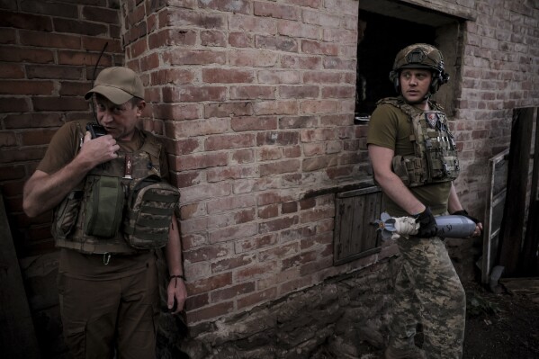 In this photo provided by the 24th Mechanised brigade press service, Ukrainian soldiers prepare to fire 120mm mortar towards Russian position on the front line at undisclosed location in Donetsk region, Ukraine, Monday, June 4, 2024. (Oleg Petrasiuk/Ukrainian 24 Mechanised brigade via AP)