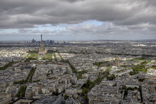 The Eiffel Tower and the Champs-de-Mars at its feet, the Invalides monument and its dome, right, are seen Monday, April 15, 2024 in Paris. The Champ-de-Mars will host the Beach Volleyball and Blind Football and the Invalides will host the Cycling road, Archery and Athetics events at the Paris 2024 Olympic and Paralympic Games. (AP Photo/Aurelien Morissard, File)