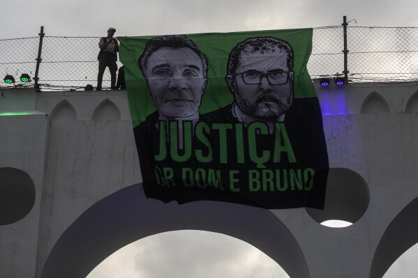 A sign that reads in Portuguese "Justice for Dom and Bruno" with images of the British journalist Dom Phillips, on the left, and the Indigenous specialist Bruno Pereira, is displayed on the Arcos da Lapa aqueduct during a protest by environmental groups to ask for justice for their deaths, in Rio de Janeiro, Brazil, June 26, 2022. (AP Photo/Bruna Prado, File)