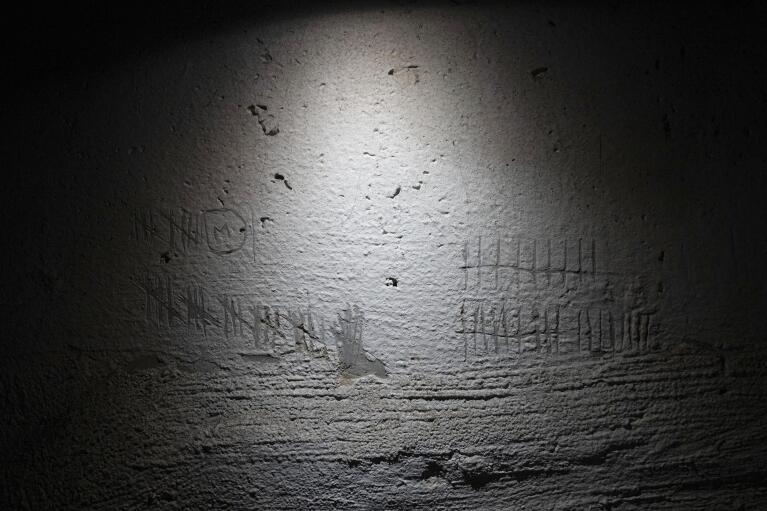 FILE - Tally marks are etched in to a wall by detainees to keep track of time in a building used, according to a war crimes prosecutor, by Russian forces as a place of torture in Kherson, Ukraine, Dec. 8, 2022. In a deliberate, widespread campaign, Russian forces systematically targeted influential Ukrainians, nationally and locally, to neutralize resistance through detention, torture and executions, an Associated Press investigation has found. (AP Photo/Evgeniy Maloletka, File)