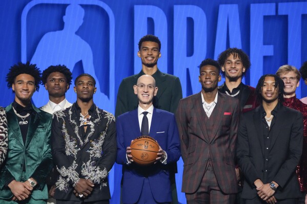 NBA Commissioner Adam Silver, center, stands for a photo with potential first-round draft picks at Barclays Center before the NBA basketball draft, Thursday, June 22, 2023, in New York. (AP Photo/John Minchillo)