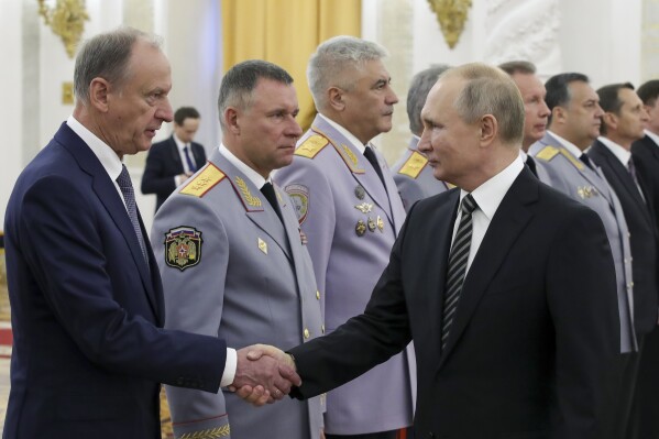 FILE - Russian President Vladimir Putin shakes hands with Russian Security Council chairman Nikolai Patrushev, left, as he greets senior military officers during a meeting in Moscow, Russia, Wednesday, Nov. 6, 2019. Patrushev could be an establishment-supported candidate for Russian president if Vladimir Putin does not run for reelection or becomes incapacitated before the vote in March 2024. (Mikhail Klimentyev, Sputnik, Kremlin Pool Photo via AP, File)