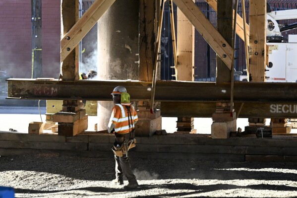 Construction workers work on the I-10 underpass, which was closed by an underpass fire on Saturday, Nov. 11, 2023, in Los Angeles, Sunday, Nov. 19. (AP Photo/Alex Gallardo)