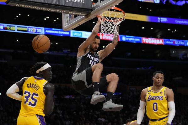 Sacramento Kings forward Trey Lyles (41) dunks against Los Angeles Lakers forward Wenyen Gabriel (35) and guard Russell Westbrook (0) during the second half of an NBA basketball game in Los Angeles, Wednesday, Jan. 18, 2023. (AP Photo/Ashley Landis)