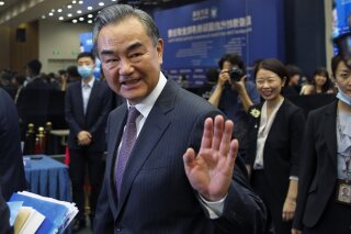 FILE - In this Sept. 28, 2020, file photo, Chinese Foreign Minister Wang Yi waves after delivering a speech at the Lanting Forum held at the Ministry of Foreign Affairs office in Beijing. While on a current trip to Malaysia, Tuesday, Oct. 13, 2020, Yi says the United States poses a “huge security risk” to Asia by pushing to boost engagement with the region. (AP Photo/Andy Wong, File)