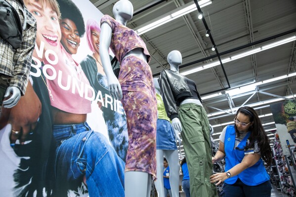 A Walmart's staff member works on a display of the No Boundaries collection at a store in Secaucus, New Jersey, Thursday, July 11, 2024. The Bentonville, Arkansas-based retailer has revamped its 30-year-old mainstay store brand for young adults called No Boundaries, which generates annual sales of $2 billion. (AP Photo/Eduardo Munoz Alvarez)