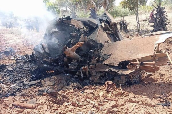 The smoking wreckage of the jet fighter that crashed in a field is seen near Kyo Wun village, Salin township in Magway region, Myanmar on Thursday, Feb.29, 2024. A Myanmar jet fighter has crashed and burned in the countryside in central Magway region, with at least one pilot safely rescued after ejecting from the aircraft. State television MRTV reported that Thursday's crash took place shortly after noon during what was described as training maneuvers and was due to a technical fault. (Salin People’s Defense Force via AP)