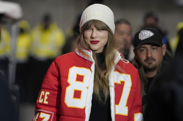 FILE - Taylor Swift wears a Kansas City Chiefs tight end Travis Kelce puffer jacket, designed by Kristin Juszczyk, as she arrives before an NFL wild-card playoff football game between the Chiefs and the Miami Dolphins, Saturday, Jan. 13, 2024, in Kansas City, Mo. (AP Photo/Ed Zurga, File)