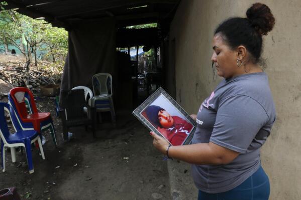 Norma Espinoza holds a portrait of her son Angel Maradiaga, at her home in Olanchito, Honduras, Saturday, May 13, 2023. Maradiaga, 17, who was detained at a facility in Safety Harbor, Florida, died Wednesday. Epinoza is demanding answers from American officials, saying her son had no known illnesses and had not shown any signs of being sick before his death. (AP Photo/Delmer Martinez)