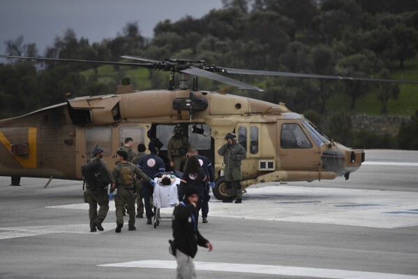 An Israeli medical team evacuate a person injured by a rocket fired from Lebanon, at Ziv hospital in Safed, northern Israel, Wednesday, Feb. 14, 2024. Israeli media reported 1 killed and eight wounded in the rocket attack. The town, which is around 12 kilometers (7 miles) from the border is farther south than most of the daily border skirmishes with Lebanon's Hezbollah militant group. (AP Photo/Gil Eliyahu)