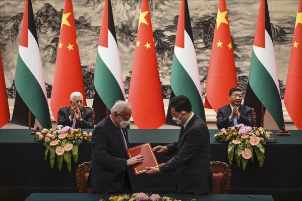 Palestinian Foreign Minister Riyad Al-Maliki, front left, attends a signing ceremony with Chinese Foreign Minister Qin Gang, front right, as Palestinian President Mahmoud Abbas, rear left, and China's President Xi Jinping applaud at the Great Hall of the People in Beijing Wednesday, June 14, 2023. (Jade Gao/Pool Photo via AP)
