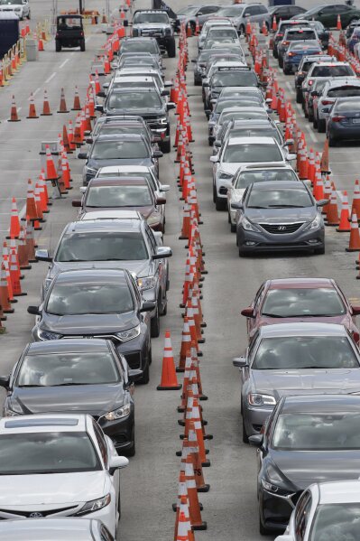 FILE - Cars wait in line at a drive-through COVID-19 testing site outside Hard Rock Stadium, in a Wednesday, July 8, 2020 file photo, in Miami Gardens, Fla. Florida on Sunday, July 13, 2020 reported the largest single-day increase in positive coronavirus cases in any one state since the beginning of the pandemic. (AP Photo/Wilfredo Lee)