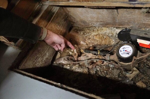 Home owner Jonathan Crossman points out the existing lead residential water supply line before the Providence Water meter in the basement of his family's home, Thursday, March 23, 2023, in Providence, R.I. Health and environmental groups have been fighting for lead-free water to drink in Providence for at least a decade. (AP Photo/Charles Krupa)