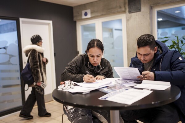 People vote during an early voting for Greenlandic parliamentary elections at the city hall in Nuuk, Greenland, Monday, March 10, 2025. (AP Photo/Evgeniy Maloletka)