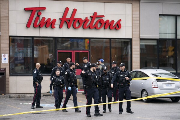 Police work the scene where a police officer was stabbed and a suspect shot in Toronto on Friday, April 12, 2024. (Arlyn McAdorey/The Canadian Press via AP)