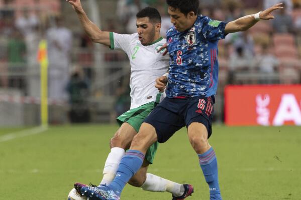 Japan's Wataru Endo, right, fights for the ball with Saudi Arabia's Sultan Al-Ghannam during their match of the Asian zone group B qualifying soccer match for the FIFA World Cup Qatar 2022 at the King Abdullah sports city stadium, in Jiddah, Saudi Arabia, Thursday, Oct. 7, 2021. (AP Photo)