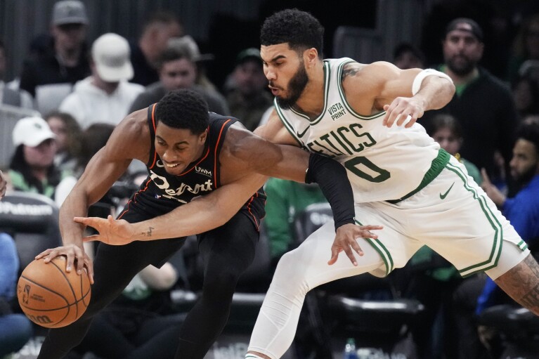 Boston Celtics forward Jayson Tatum (0) battles Detroit Pistons guard Jaden Ivey (23) for the ball during the second half of an NBA basketball game, Thursday, Dec. 28, 2023, in Boston. (AP Photo/Charles Krupa)
