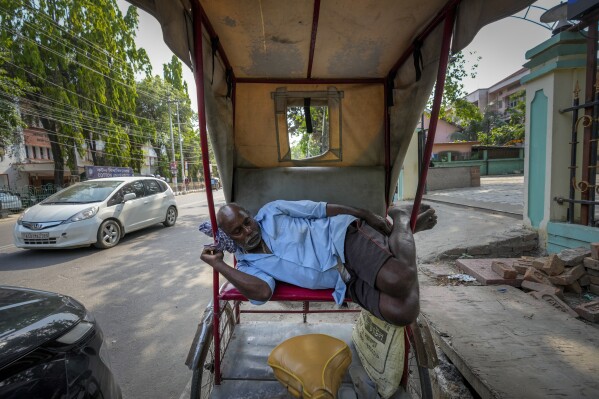 A rickshaw puller sleeps in the shade of a tree on a hot summer afternoon in Guwahati, India, Friday, May 3, 2024. (Ǻ Photo/Anupam Nath)