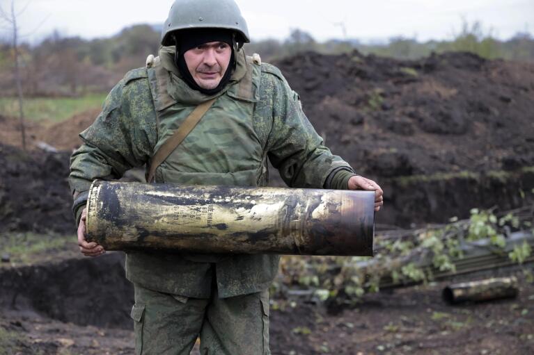 FILE - A serviceman carries an artillery shell after firing at Ukrainian troops at an undisclosed location in the Russian-controlled Donetsk region of eastern Ukraine, on Oct. 11, 2022. While Russia is pressing its goals in the war, Ukraine and its Western allies stand firmly to prevent Moscow from having any territorial gains. (AP Photo/Alexei Alexandrov, File)