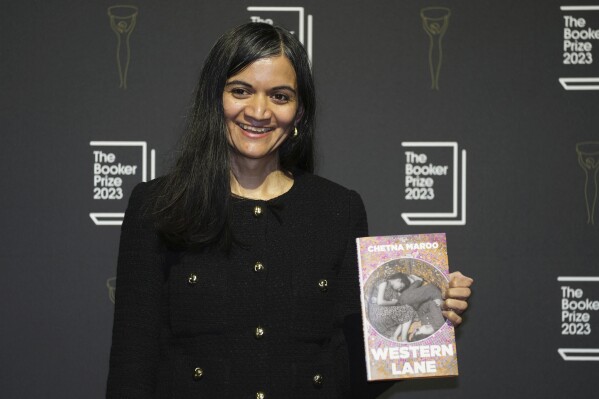 FILE - British author Chetna Maroo poses with her book "Western Lane" during a photocall with the six shortlisted authors for the Booker Prize 2023, in London, Thursday, Nov. 23, 2023 ahead of the award ceremony on Nov. 26 in London. Novels that give voice to the often unheard stories of migrants around the world are among the nominees for the 2024 Women’s Prize for Fiction on Tuesday, March 5, 2024. One of the debut novelists, British author Chetna Maroo, was a finalist for the 2023 Booker Prize with “Western Lane,” the story of a squash prodigy grappling with family tragedy. (AP Photo/Kin Cheung, File)