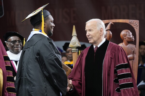 President Joe Biden, right, congratulates valedictorian DeAngelo Jeremiah Fletcher at the Morehouse College commencement Sunday, May 19, 2024, in Atlanta. (AP Photo/Alex Brandon)