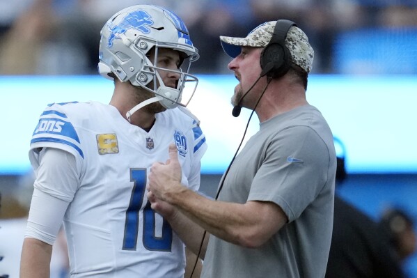 CORRECTS TO DETROIT LIONS HEAD COACH DAN CAMPBELL NOT LOS ANGELES CHARGERS HEAD COACH DAN CAMPBELL - Detroit Lions head coach Dan Campbell, right, talks to quarterback Jared Goff (16) during the second half an NFL football game against the Los Angeles Chargers, Sunday, Nov. 12, 2023, in Inglewood, Calif. (AP Photo/Ashley Landis)