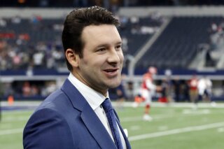 FILE - In this Nov. 5, 2017, file photo, CBS football analyst Tony Romo walks across the field during warm ups before an NFL football game between the Kansas City Chiefs and Dallas Cowboys, in Arlington, Texas. Romo will remain with CBS as its top NFL analyst after agreeing to a record extension. CBS Sports spokeswoman Jen Sabatelle said that the network and Romo have agreed to a long-term contract. (AP Photo/Michael Ainsworth, File)