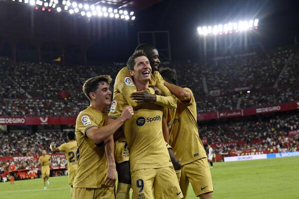 Barcelona's Robert Lewandowski, center, celebrates with teammates after scoring his side's second goal during the Spanish La Liga soccer match between Sevilla and Barcelona in Seville, Spain, Saturday, Sept. 3, 2022. (AP Photo/Jose Breton)