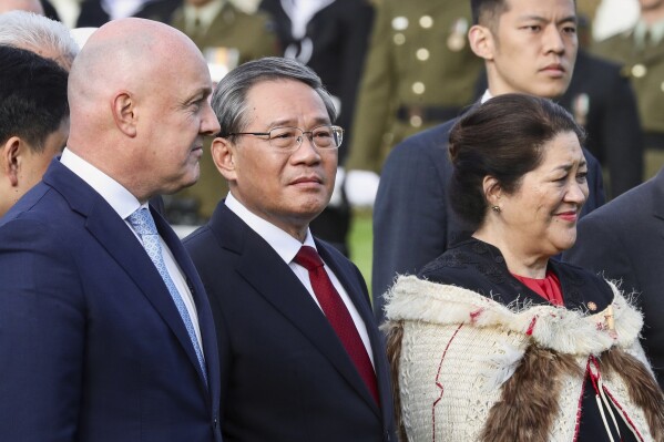Chinese Premier Li Qiang, centre, stands with New Zealand Prime Minister Christopher Luxon, left, and New Zealand Governor General Dame Cyndi Kiro during the official welcome ceremony in Wellington, New Zealand, Thursday, June 13, 2024. Li has arrived in New Zealand at the start of a weeklong tour that also includes Australia and Malaysia. (Mark Mitchell/NZ Herald via AP)