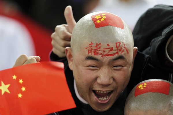 A Chinese soccer fan cheers for his team before their AFC Asian Cup group A soccer match against Qatar in Doha, Qatar, on Jan. 12, 2011. (AP Photo/Hassan Ammar, File)