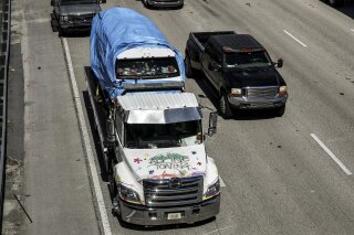 The van that federal agents are investigating in connection with package bombs that were sent to high-profile critics of President Donald Trump is transported on a flatbed tow truck on Friday, Oct. 26, 2018 in Miramar, Fla. Federal authorities took Cesar Sayoc into custody Friday in connection with the mail-bomb scare that earlier widened to 12 suspicious packages sent to prominent Democrats from coast to coast. (Carline Jean/South Florida Sun-Sentinel via AP)