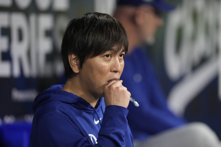 Ippei Mizuhara, interpreter for Los Angeles Dodgers designated hitter Shohei Ohtani, stands in the dugout during the baseball season opener against the San Diego Padres held at Gocheok Sky Dome in Seoul, South Korea on Wednesday, March 20, 2024. Otani's best friend was fired from his job as an interpreter. The Dodgers made the announcement following allegations of illegal gambling and theft from a Japanese baseball star.  (AP Photo/Lee ​​Jin Man)