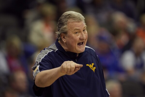 FILE - West Virginia head coach Bob Huggins talks to his players during the first half of an NCAA college basketball game against Texas Tech in the first round of the Big 12 Conference tournament Wednesday, March 8, 2023, in Kansas City, Mo. Former West Virginia men’s basketball coach Bob Huggins has entered a 12-month diversion program to resolve a drunken driving arrest. Huggins had been scheduled for a formal arraignment on Thursday, Aug. 17. According to court records in Pittsburgh, that hearing was canceled last month after he was accepted into the program. (AP Photo/Charlie Riedel, File)