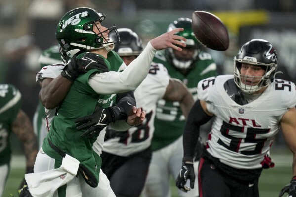 New York Jets quarterback Trevor Siemian (14) is hit while passing against the Atlanta Falcons during the fourth quarter of an NFL football game, Sunday, Dec. 3, 2023, in East Rutherford, N.J. (AP Photo/Seth Wenig)