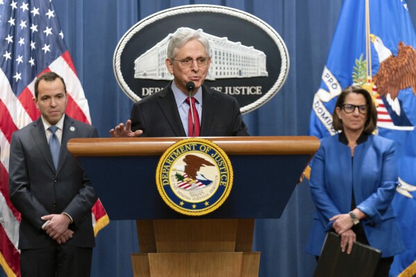 Attorney General Merrick Garland accompanied by New Jersey Attorney General Matthew Platkin and Deputy Attorney General Lisa Monaco, speaks during a news conference at the Department of Justice headquarters in Washington, Thursday, March 21, 2024. The Justice Department on Thursday announced a sweeping antitrust lawsuit against Apple, accusing the tech giant of engineering an illegal monopoly in smartphones that boxes out competitors and stifles innovation. (AP Photo/Jose Luis Magana)