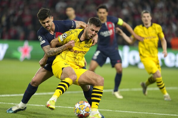 PSG's Lucas Beraldo, left, challenges for the ball with Dortmund's Niclas Fuellkrug during the Champions League semifinal second leg soccer match between Paris Saint-Germain and Borussia Dortmund at the Parc des Princes stadium in Paris, France, Tuesday, May 7, 2024. (AP Photo/Lewis Joly)