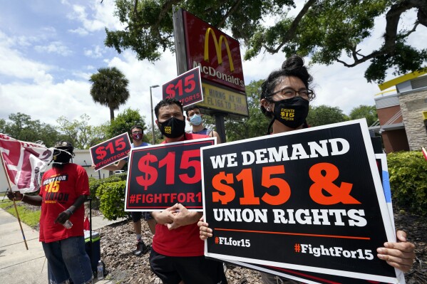FILE - Workers and family members take part in a 15-city walkout to demand $15 per hour wages on May 19, 2021, in front of a McDonald's restaurant in Sanford, Fla. A federal rule that goes into effect next month could make it easier for millions of workers to form unions at big companies like McDonald's. But it's already facing significant pushback from businesses and some members of Congress. (AP Photo/John Raoux, File)