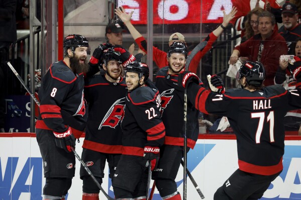 Carolina Hurricanes' Jack Roslovic, second left, celebrates his goal with Brent Burns (8), Logan Stankoven (22), Jesperi Kotkaniemi (82) and Taylor Hall (71) during the second period of Game 3 of an NHL hockey Semi-final round playoff series against the Washington Capitals in Raleigh, N.C., Saturday, May 10, 2025. (AP Photo/Karl DeBlaker)