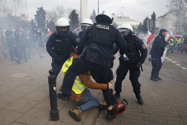 Police officers detain a man during farmers protest in Warsaw, Poland, on Wednesday March 6, 2024. The protest ratchets up pressure on the government as they demand the Poland-Ukraine border closed to food imports and demand changes to European Union climate and agricultural policies. (AP Photo/Michal Dyjuk)