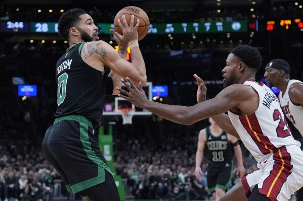 Boston Celtics forward Jayson Tatum (0) looks to pass while pressured by Miami Heat forward Haywood Highsmith (24) during the first half of Game 5 of an NBA basketball first-round playoff series, Wednesday, May 1, 2024, in Boston. (AP Photo/Charles Krupa)