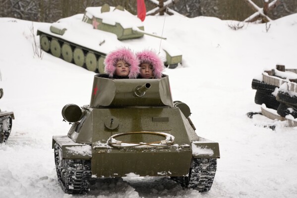 Children ride a model of World War II-era Soviet tank during a military historical festival at the family historical tank park outside St. Petersburg, Russia, on Feb. 4, 2023. (AP Photo/Dmitri Lovetsky)