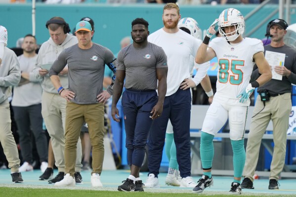 Miami Dolphins wide receiver Tyreek Hill, center, watches from the sidelines during the first half of an NFL football game against the New York Jets, Sunday, Dec. 17, 2023, in Miami Gardens, Fla. (AP Photo/Lynne Sladky)