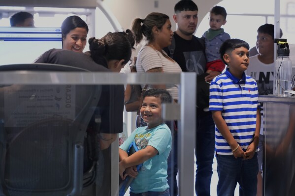 Customs and Border Protection officers process visitors, students and commuters who crossed the pedestrian bridge in Laredo, Texas, on Friday, Aug. 9, 2024. (AP Photo/Eric Gay)