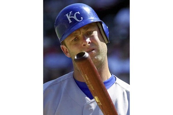 FILE - Kansas City Royals batter Dave McCarty inspects his bat after hitting a foul ball during the seventh inning against the Texas Rangers in a baseball game in Arlington, Texas, May 31, 2001. McCarty, a member of the Boston Red Sox championship team in 2004 who played with seven MLB teams in an 11-year career, has died. He was 54. The Red Sox announced McCarty's death in a statement, saying the former first baseman and outfielder died Friday, April 19, 2024, after suffering a cardiac event in Oakland, Calif. (AP Photo/Bill Janscha, File)
