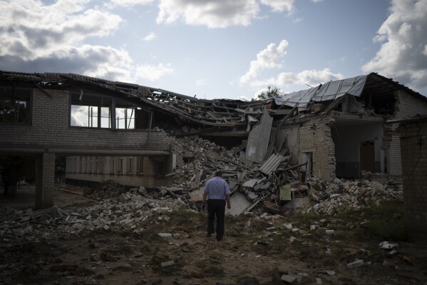 Oleksandr Pishchyk, a school director, stands in front of the school library that was destroyed by shelling in Kupiansk, Ukraine, Wednesday, Aug. 23, 2023. (AP Photo/Bram Janssen)