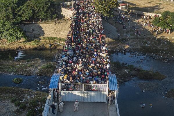 FILE - Haitians wait to cross the border between Dominican Republic and Haiti in Dajabon, Dominican Republic, Friday, Nov. 19, 2021. As Haiti’s crisis, exacerbated by the 2021 assassination of ex-Haitian President Jovenel Moïse, has only deepened and spurred on a massive flight of migrants, the Dominican Republic has gradually grown more hardline with its migratory and border policies. (AP Photo/Matias Delacroix, File)