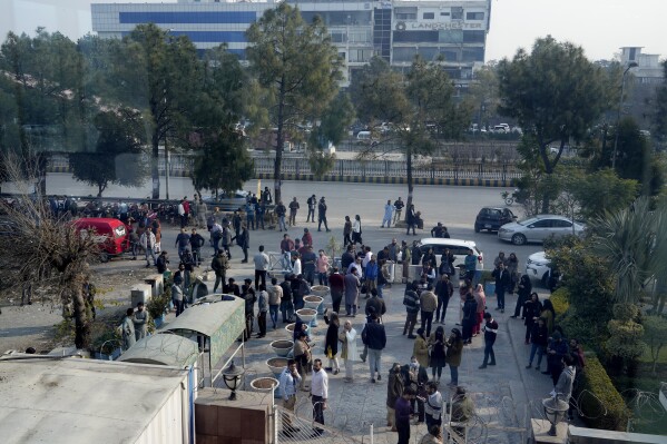 People stand outside their offices building after an earthquake was felt in Islamabad, Pakistan, Thursday, Jan. 11, 2024. A magnitude 6.4 earthquake rattled much of Pakistan and part of neighboring Afghanistan on Thursday, sending panicked residents fleeing from homes and offices and especially frightening people in remote villages across the country, Pakistani officials and the U.S. Geological Survey said. (AP Photo/Anjum Naveed)