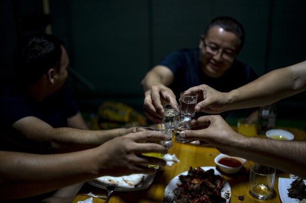 Men enjoy their time in a restaurant in Nukus, Uzbekistan, Friday, June 23, 2023. (AP Photo/Ebrahim Noroozi)